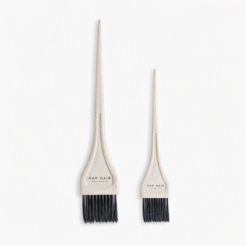 Two beige hair dye applicator brushes with black bristles, one large and one small, both branded 'NAK HAIR AUSTRALIA' on the handles, set against a plain white background.