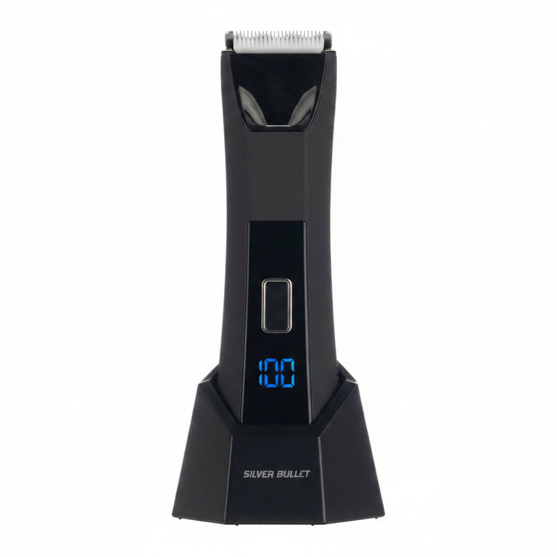 A black electric hair trimmer with a digital display showing '100' in blue, labeled 'SILVER BULLET' on the base, shown against a split white and dark textured background.