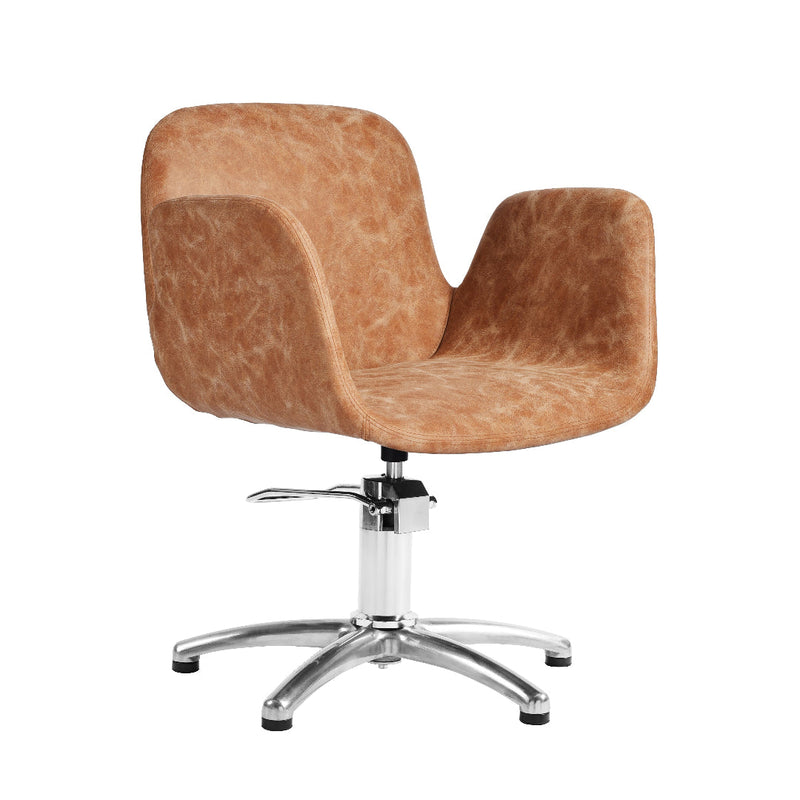 A modern salon chair with a curved, bucket-style upholstered seat and back in a warm tan-brown textured fabric, supported by a chrome-plated five-star base on a white background.