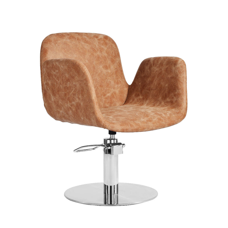 A modern salon hairdressers chair with a curved, sculptural seat upholstered in a textured tan-brown faux leather, mounted on a chrome-plated swivel base with a footrest.